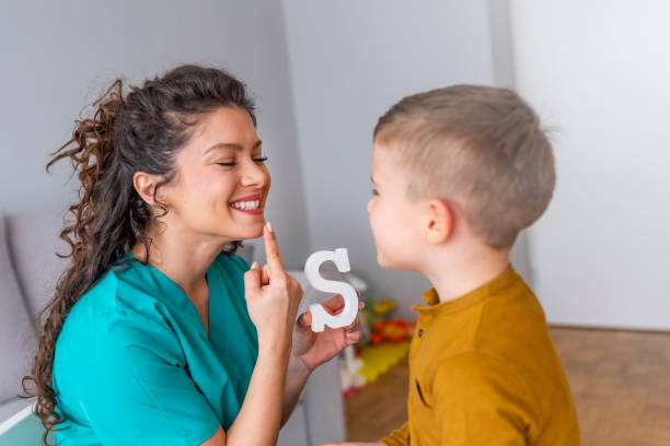 Speech therapist working with child on oral-motor exercises